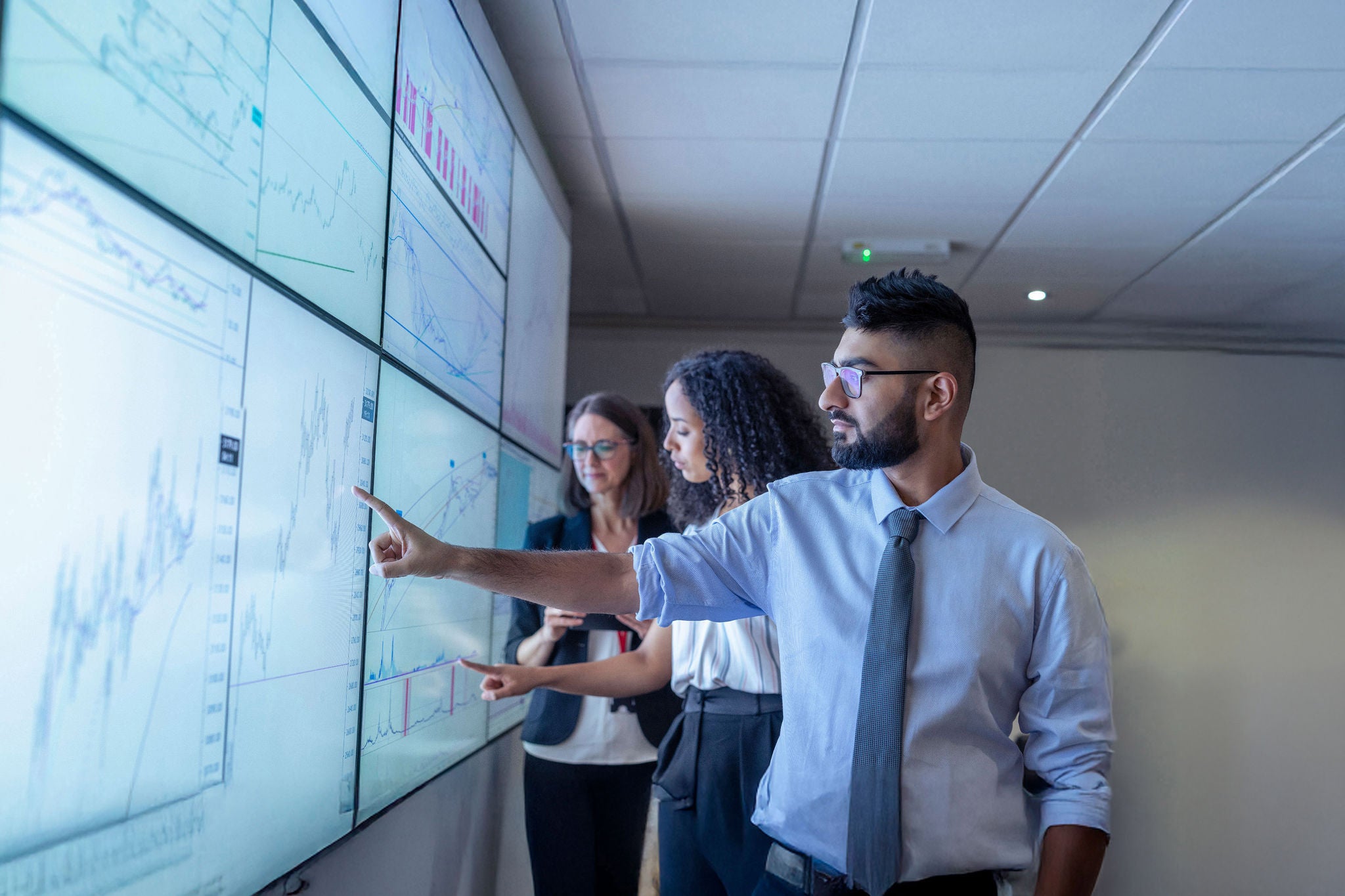 UK, York, Business people discussing charts on interactive screens
