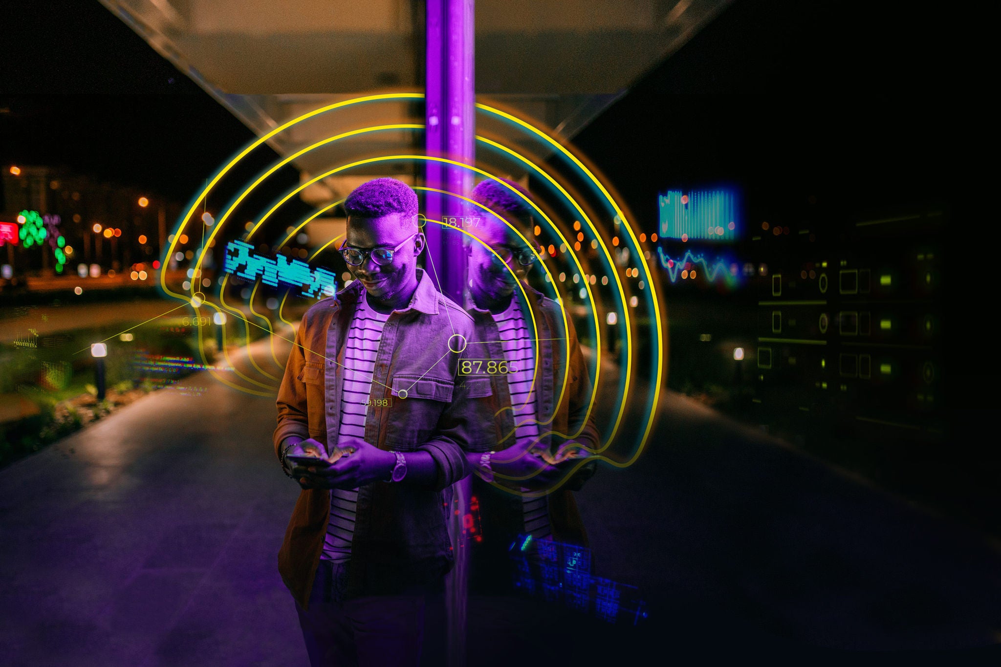 Young handsome black man using phone, typing text message in a front of neon blue light office window in rainy night