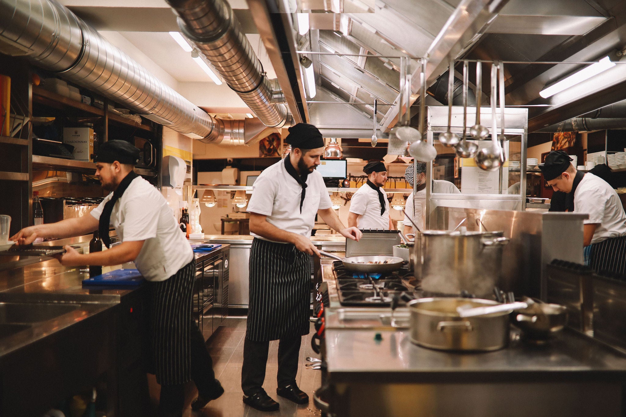 Restaurant kitchen crew preparing food.