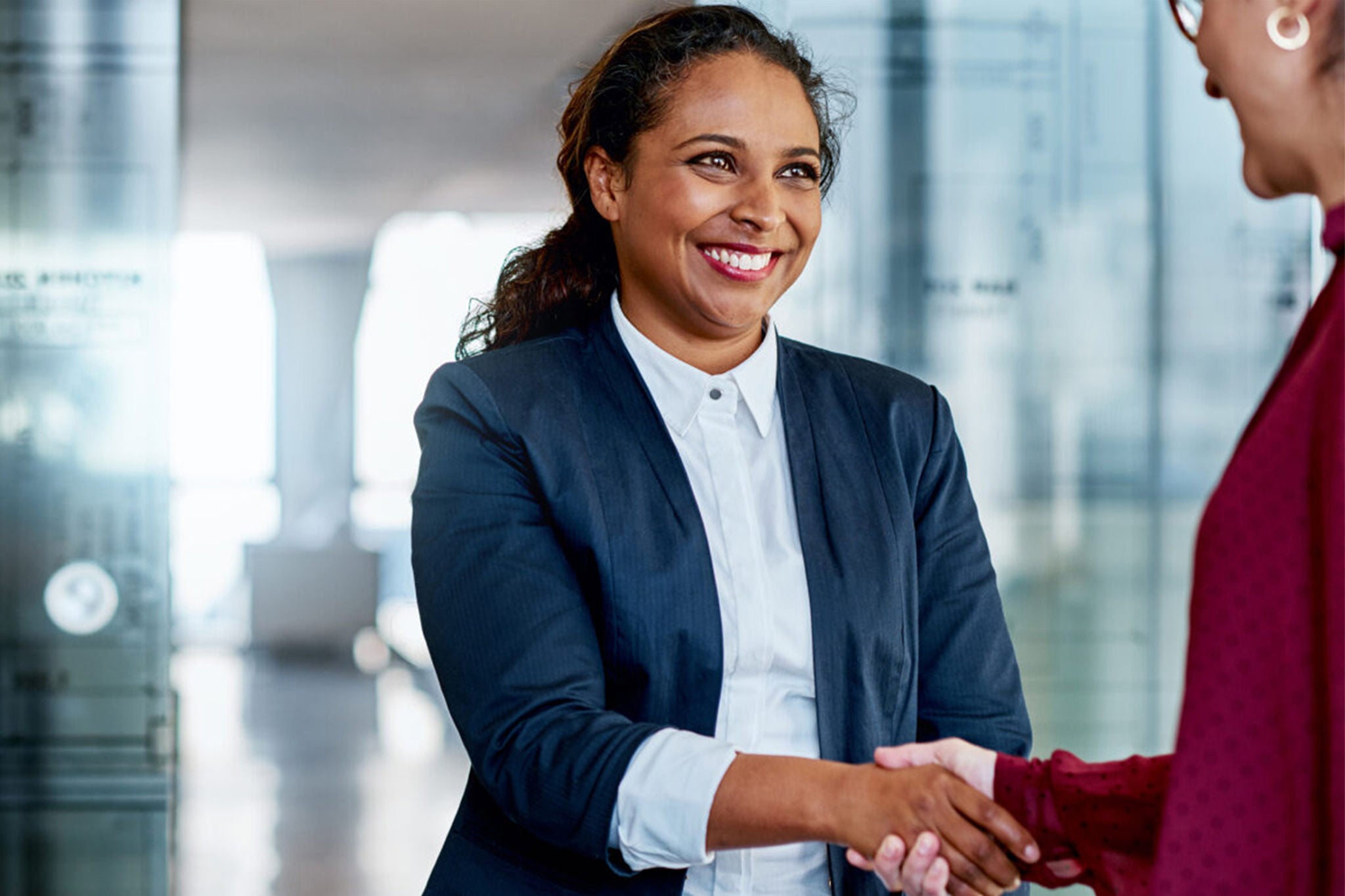 Shot of two businesswomen shaking hands in a modern office