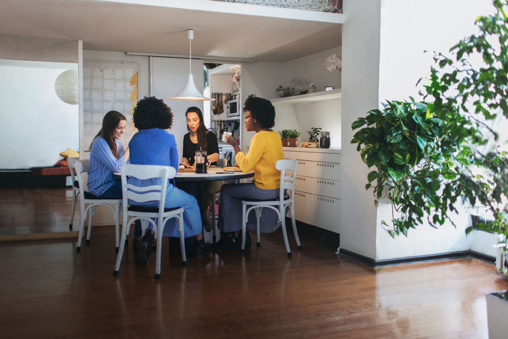 Group of young women roommates having breakfast together
