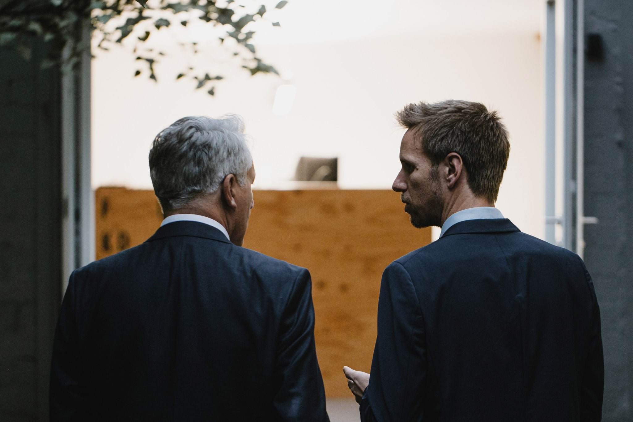 Two businessmen talking in office, rear view 
