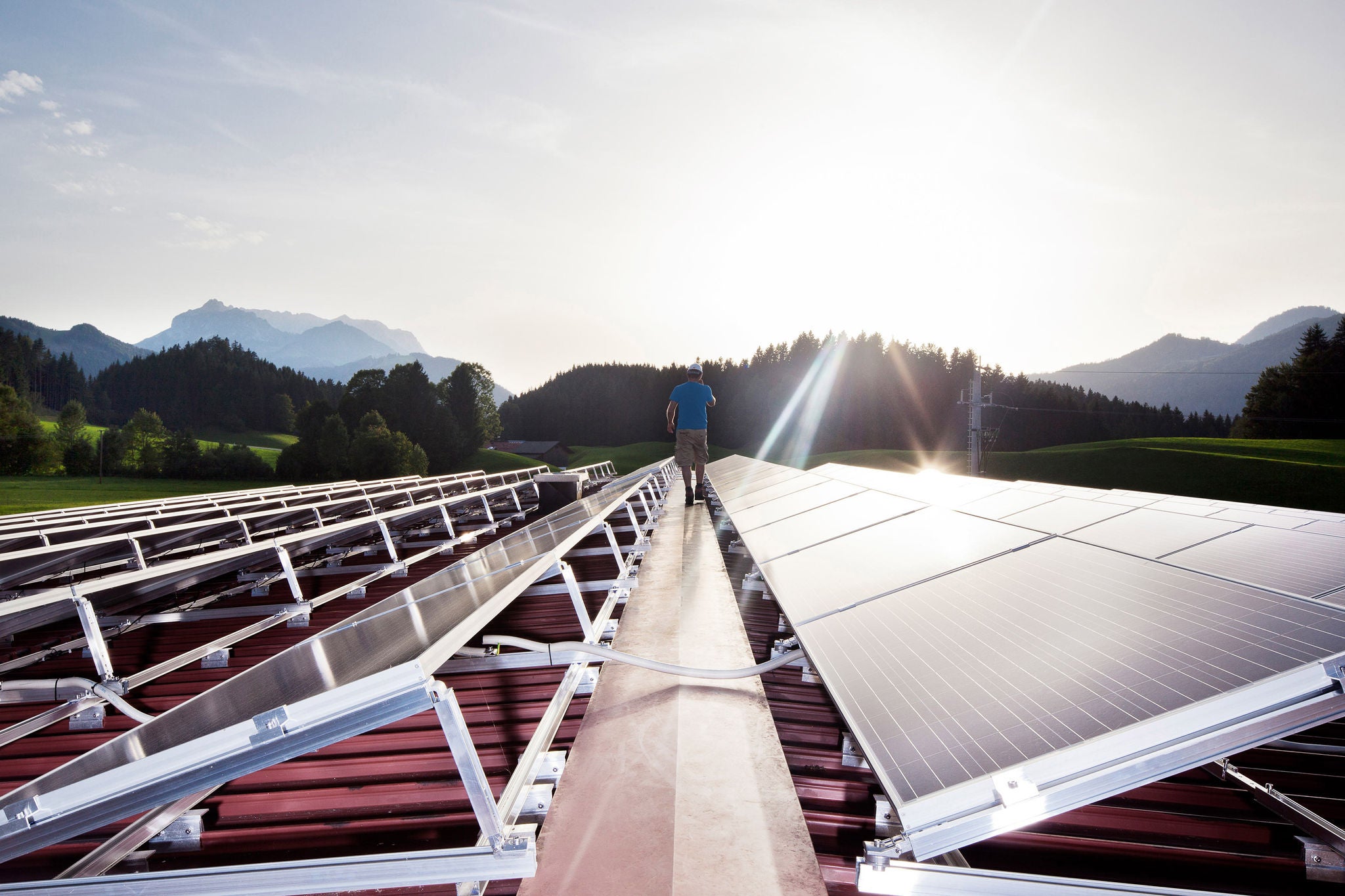 worker walking on solar plant in the evening