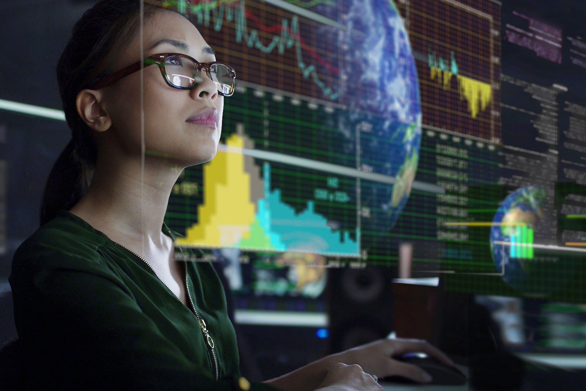 Woman looking at see through screen showing global environmental data