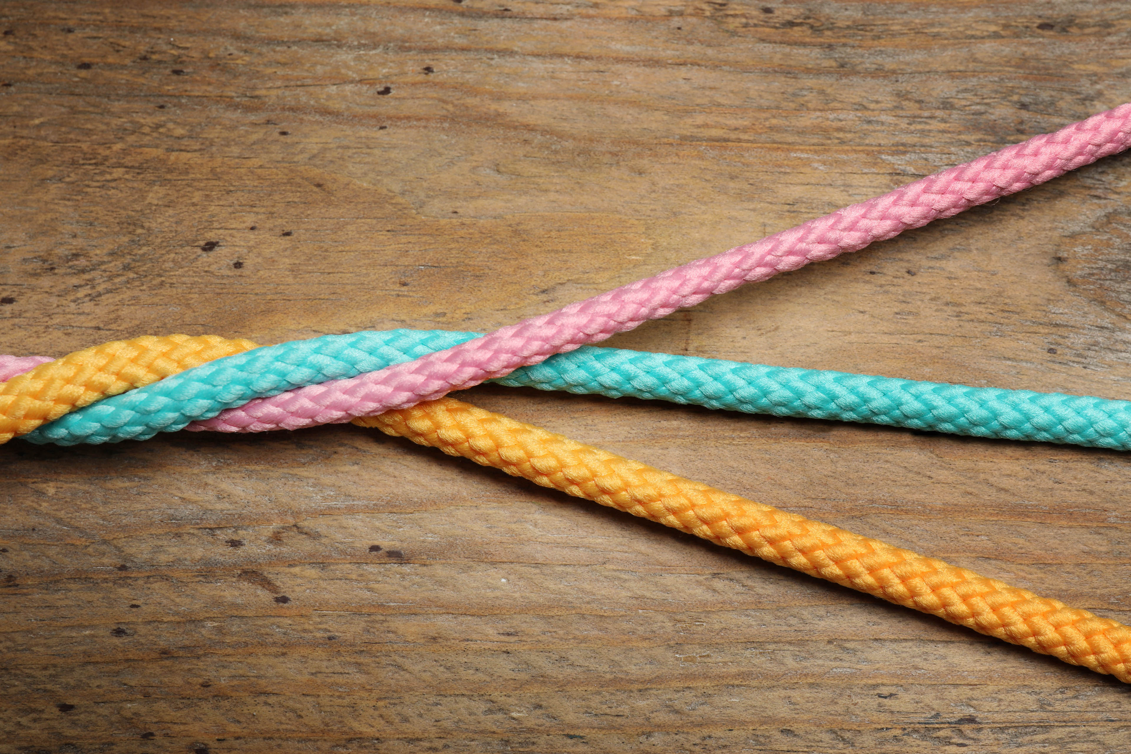 Twisted colorful ropes on wooden background